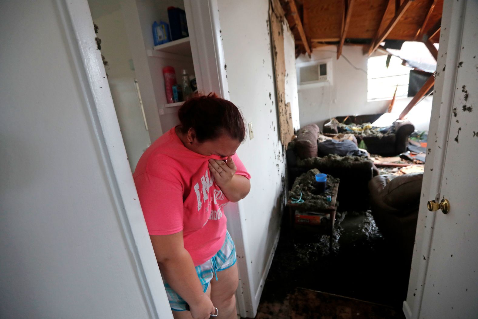 Kaylee O'Brian cries inside her Panama City home after several trees fell on it on October 10.