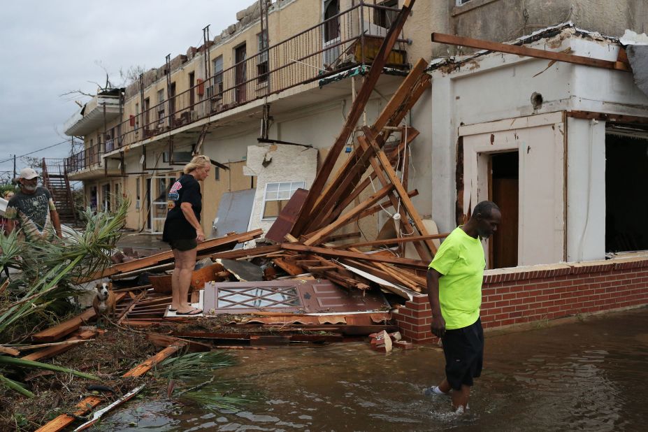 People make their way through a building's wreckage in Panama City on October 10.