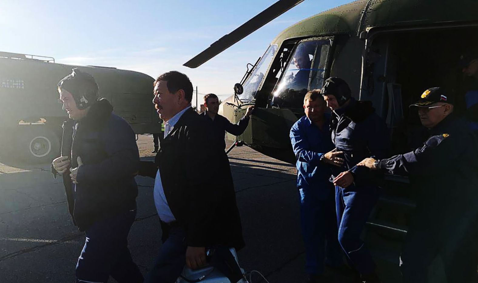 Alexey Ovchinin, left, and Nick Hague are escorted by officials after returning to Earth.