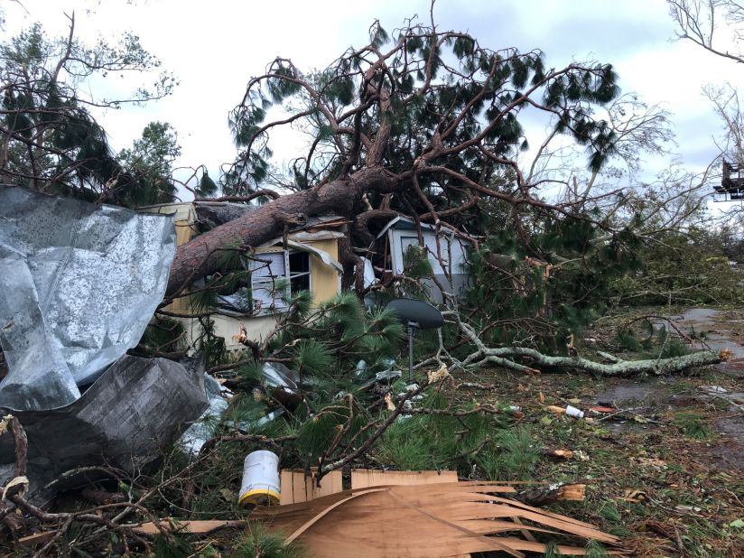 A tree sits on top of a Panama City mobile home. Almost all the residents of the mobile-home park rode out the storm. All homes were damaged except one.
