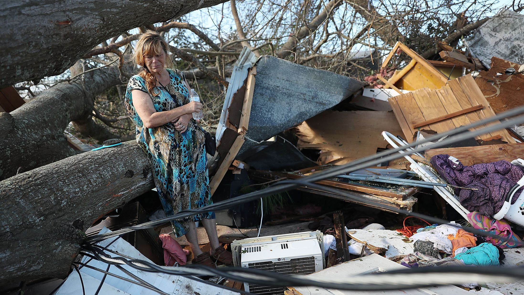 Kathy Coy stands among what is left of her home in Panama City. She said she was in the home when it was blown apart and is thankful to be alive.