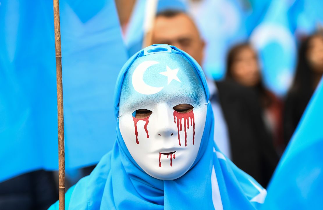 A person wearing a white mask with tears of blood takes part in a protest march of ethnic Uyghurs asking for the European Union to call upon China to respect human rights Xinjiang in April 2018. 