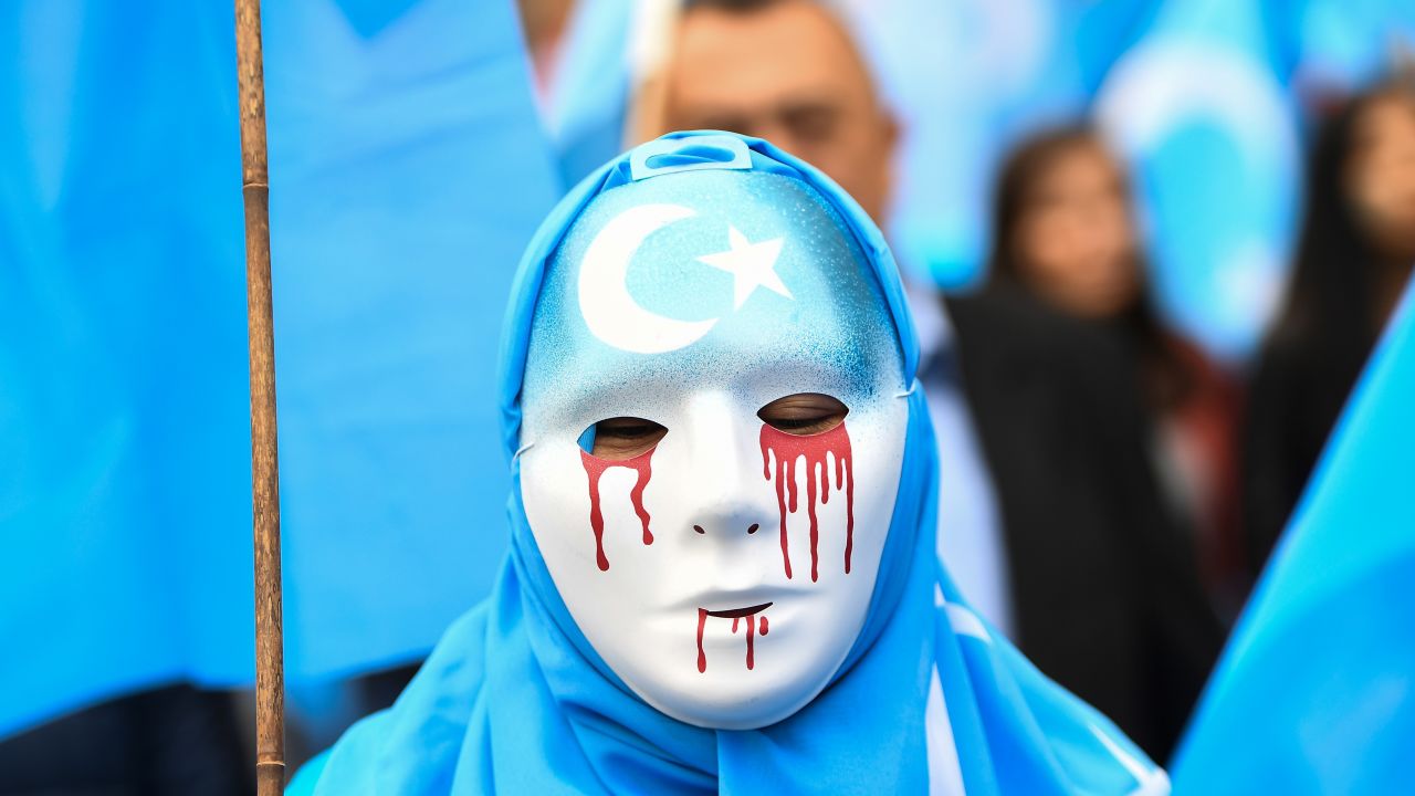 A person wearing a white mask with tears of blood takes part in a protest march of ethnic Uyghurs asking for the European Union to call upon China to respect human rights Xinjiang in April 2018.