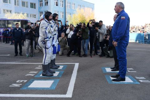 Nick Hague and Alexey Ovchinin report to Roscosmos head Dmitry Rogozin before boarding the Soyuz MS-10 spacecraft.