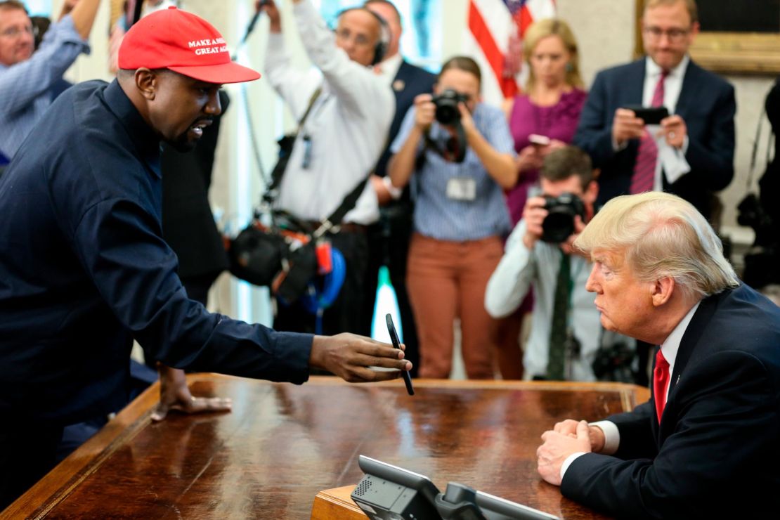Rapper Kanye West , left, shows a picture of a plane on a phone to U.S. President Donald Trump during a meeting in the Oval office of the White House on October 11, 2018 in Washington, DC. 
