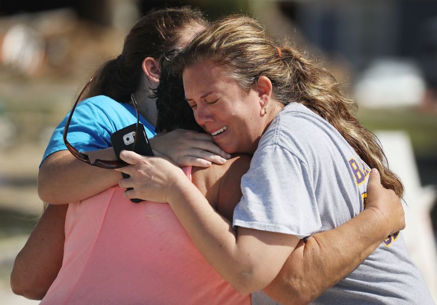 Elizabeth Hanson, right, and her daughter Emaly hug their neighbor Cindy Clark on October 11. The hurricane heavily damaged their homes in Mexico Beach.