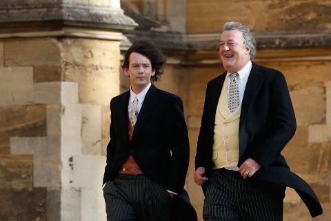 Stephen Fry and his husband Elliott Spencer walk toward the chapel..
