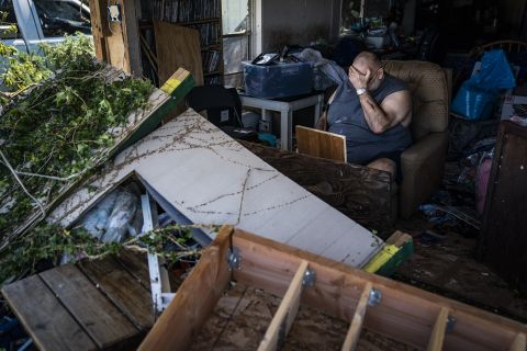 Benny Hobson sits in his recliner on Thursday, October 11, after losing the front wall of his house in Panama City, Florida.