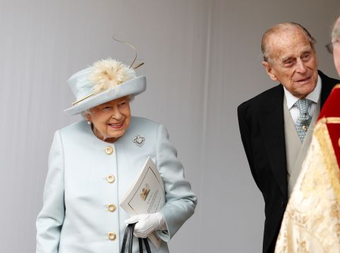 Britain's Queen Elizabeth II and Prince Philip wait for the arrival by open carriage of Princess Eugenie and Jack Brooksbank following their wedding.