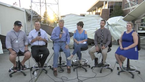 WMBB journalists anchor from the parking lot after their newsroom suffered damage from Hurricane Michael