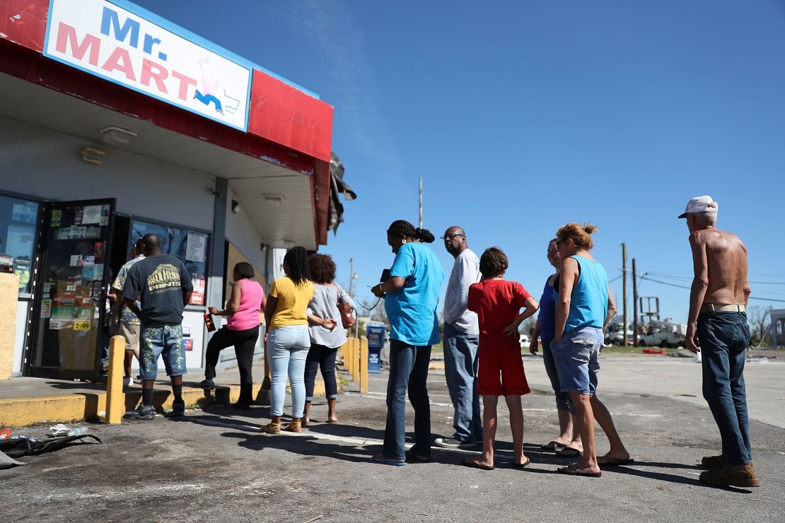 People line up Friday outside a Panama City convenience store in the aftermath of Hurricane Michael.