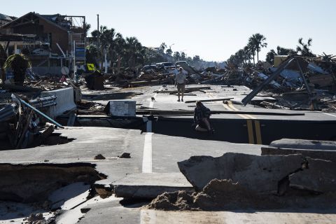 Mexico Beach residents make their way across a washed-out road on Friday, October 12.