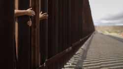 People reach through the wall from the Mexican side at the conclusion of the Hugs Not Walls event on the U.S.-Mexico border on October 13, 2018 in Sunland Park, New Mexico. More than 200 families with mixed immigration status living in the U.S. were allowed to reunify with relatives in Mexico for three minutes after Border Patrol briefly opened the border wall to allow the reunions. The event is approved by the U.S. government as families keep their feet on their respective sides of the border. The event is normally held in downtown El Paso but was moved to New Mexico due to new construction of an 18-foot border wall in El Paso.