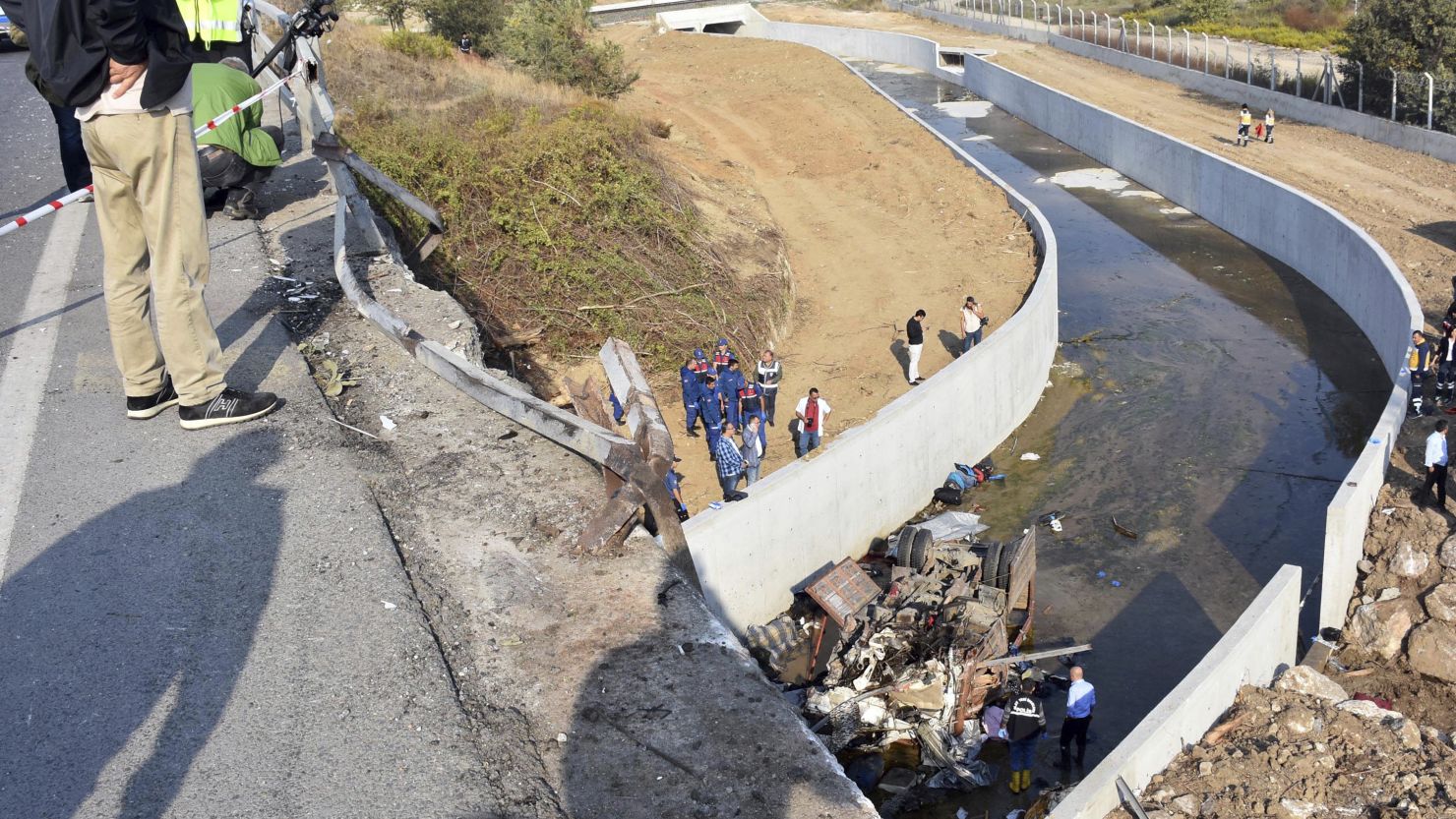 Rescue workers inspect an overturned truck in Izmir province.