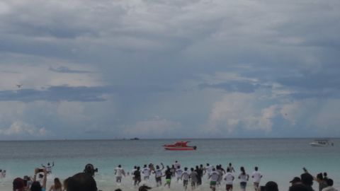 Tourists taking part in Boracay's limited-access soft opening run into the water following the island's six-month cleanup.