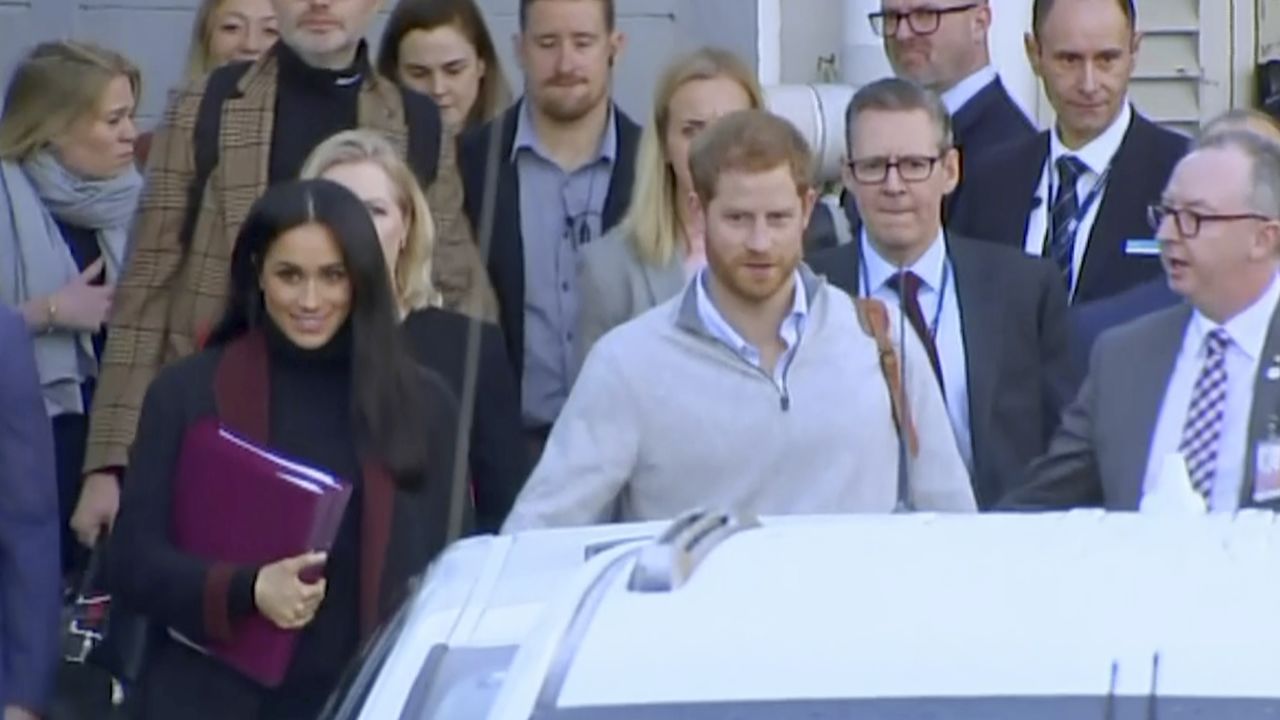 Britain's Prince Harry, center right, and his wife Meghan Markle, left, approach a car at an airport in Sydney on Monday.
