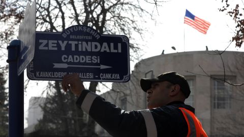 In February, a worker changes a sign to rename the street leading to the current US Embassy in Ankara to "Olive Branch Avenue."