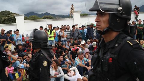 A caravan of Honduran migrants pauses at a Guatemalan police checkpoint after crossing the border from Honduras on October 15.