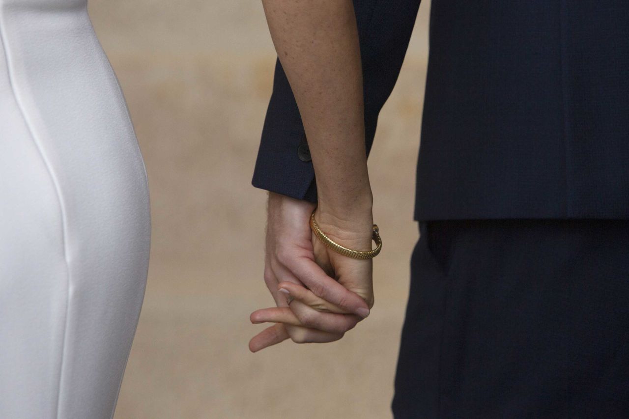 The Duke and Duchess hold hands as they walk inside after posing for a photo in Sydney.
