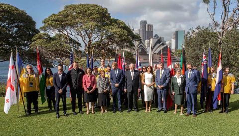 Harry and Meghan pose for a group photo at Admiralty House in Sydney with Cosgrove (front row, sixth from left); his wife, Lynn Cosgrove (fourth from left); and representatives of countries participating in the Invictus Games.