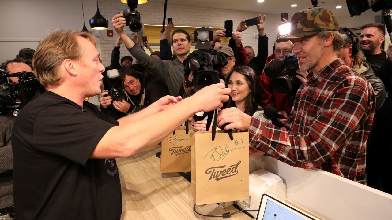 Canopy Growth CEO Bruce Linton hands Ian Power, who is first in line to purchase the first legal recreational marijuana after midnight, his purchases at a Tweed retail store in St John's, Newfoundland and Labrador, Canada October 17, 2018. REUTERS/Chris Wattie
