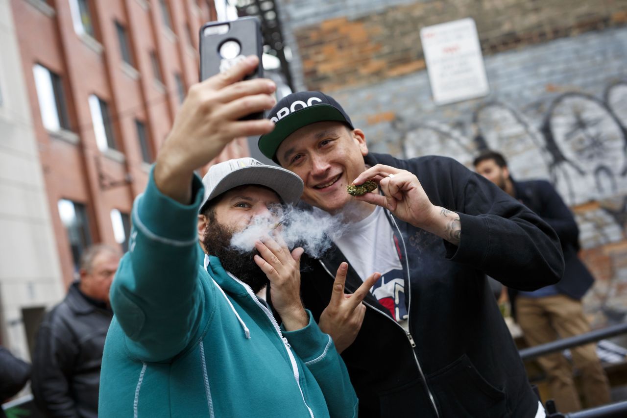 People pose for a selfie while smoking a joint in Toronto.