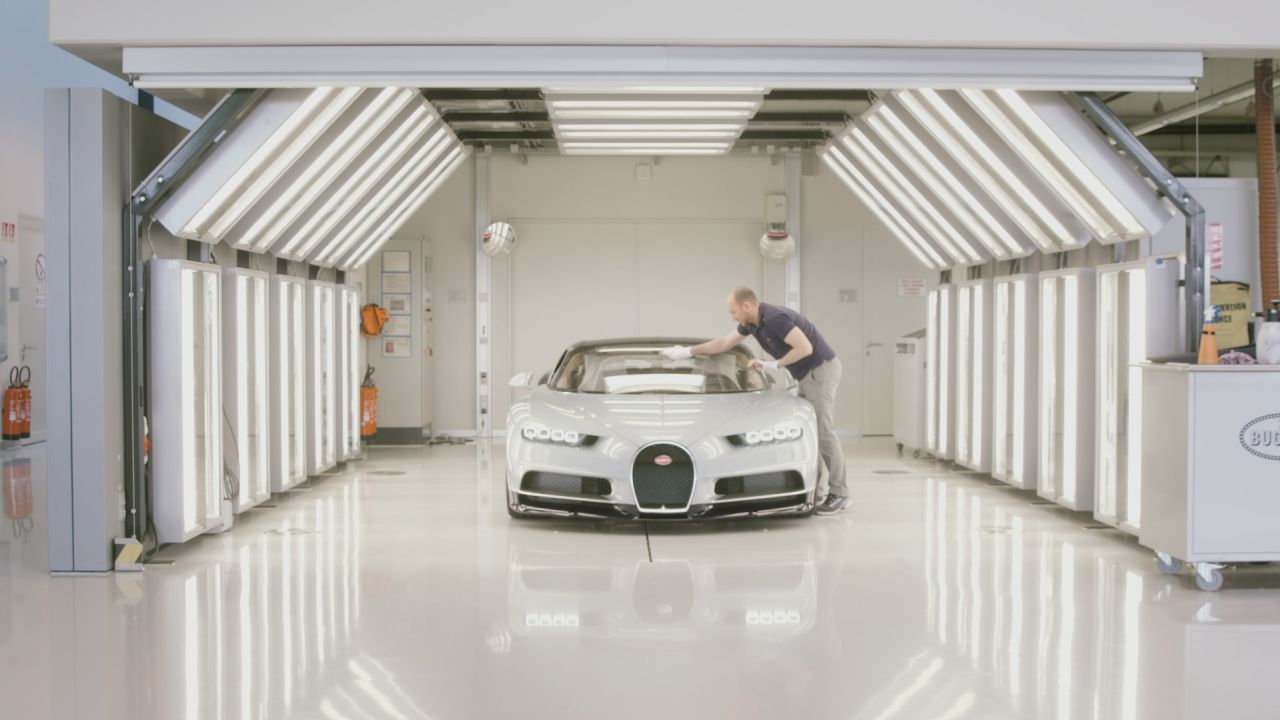 At the Bugatti factory in Molsheim, France, a worker carefully inspects a Bugatti Chiron.