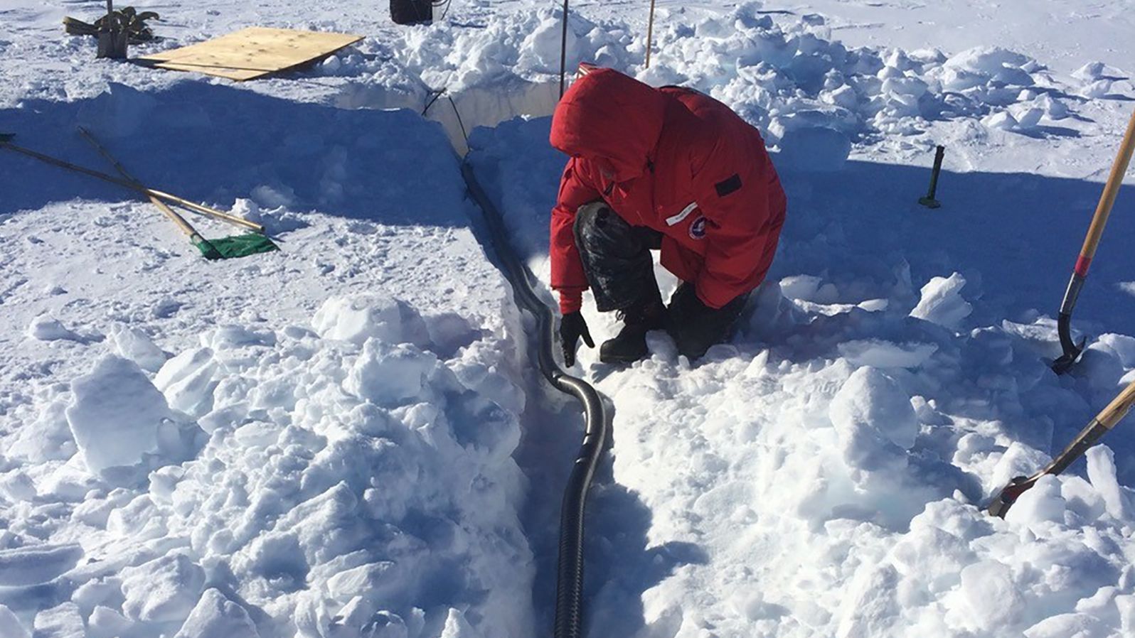 A researcher lays the conduit that connects the seismometer to the solar power system.