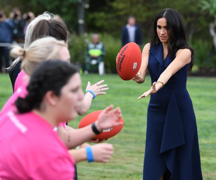 Meghan holds an Australian rules football during a reception given by Dessau.