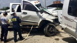 In this March 31, 2017 file photo provided by National Transportation Safety Board, Kristin Poland and David Pereira examine the pickup truck involved in a crash on March 29 on U.S. 83 near Garner State Park in Texas. Federal officials say a motorist's use of marijuana and a sedative led to the collision with the church bus that killed 13 people. 