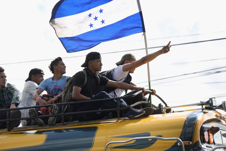 Migrants display the flag of Honduras while on a caravan of migrants en route to the Mexican border on Thursday in Guatemala City. The caravan of thousands of Central Americans, most from Honduras, hopes to eventually reach the United States. President Donald Trump has threatened to cancel the recent trade deal with Mexico and withhold aid to Central American countries if the caravan isn't stopped before reaching the United States. 