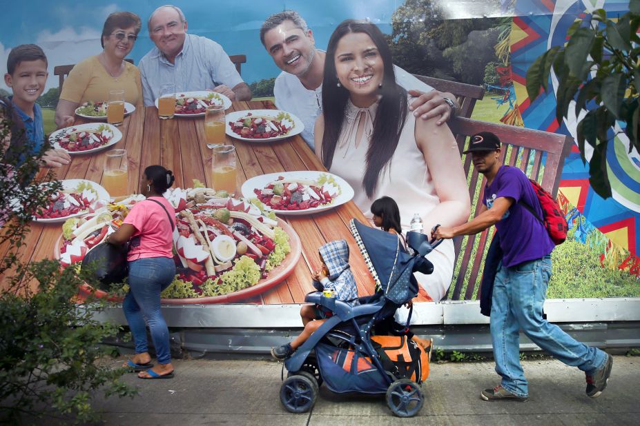 A Honduran migrant, part of a caravan trying to reach the United States, pushes a stroller with a boy during a new leg of their travel in Guatemala City on Thursday.