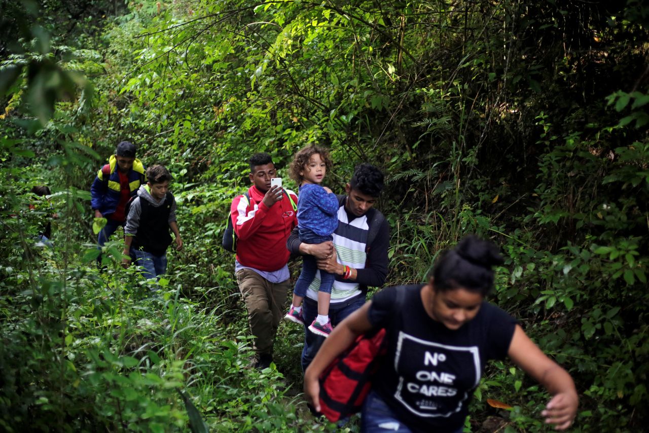 Honduran migrants hike in the forest after crossing the Lempa River, on the border between Honduras and Guatemala, to join the caravan on Thursday.