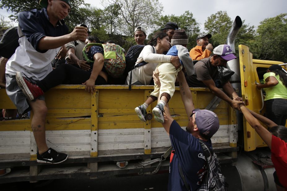 Honduran migrants climb into the bed of a truck in Zacapa, Guatemala, on Wednesday, October 17, 2018. 