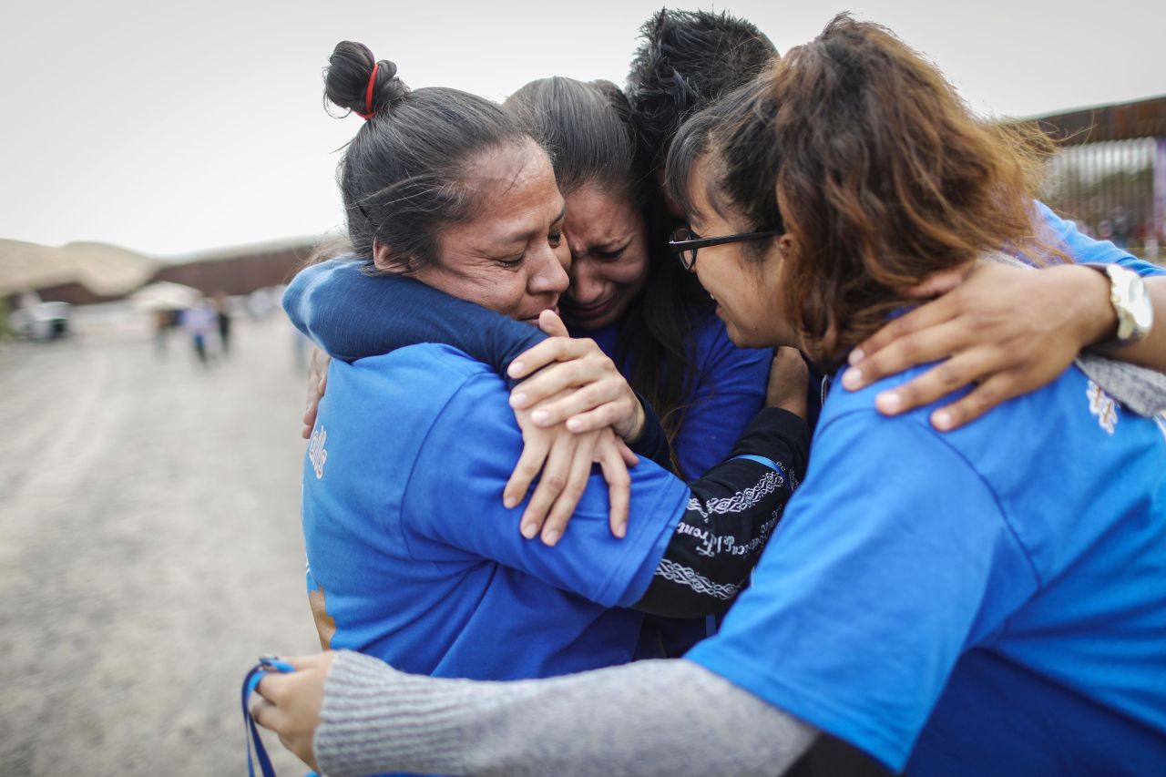 Iliana Nieves, left, hugs family members after she was briefly reunited with her mother on the other side of the wall at the Hugs Not Walls event on the US-Mexico border in Sunland Park, New Mexico, on Saturday, October 13. More than 200 families with mixed immigration status living in the United States were allowed to reunify with relatives in Mexico for three minutes after Border Patrol briefly opened the border wall to allow the reunions. 