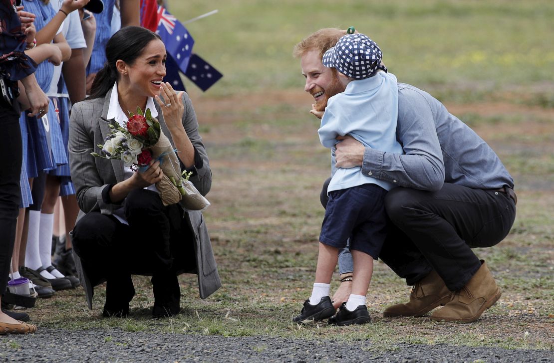 Britain's Prince Harry and Meghan, Duchess of Sussex are embraced by Luke Vincent, 5, on their arrival in Dubbo, Australia.