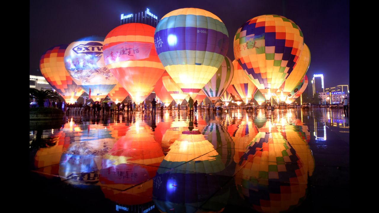 People look at hot air balloons decorating a plaza during a tourism event in China on Sunday, October 14. 