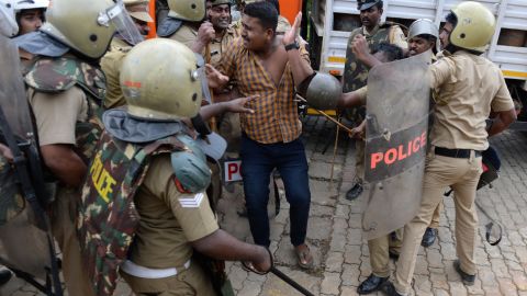 Police take a Hindu activist into custody as protesters rally against the Supreme Court verdict.