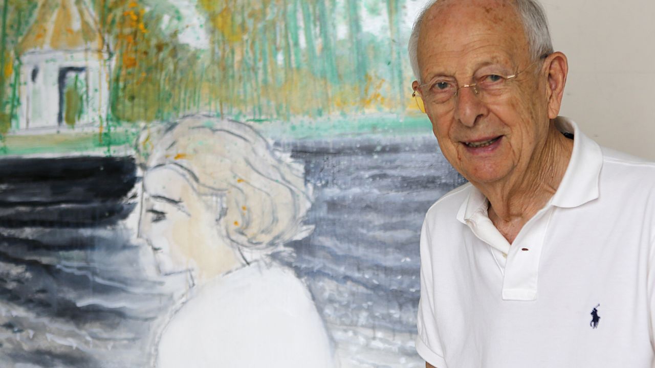 Brasilier posing next to a painting of his wife, Chantal, who is another of his inspirations.