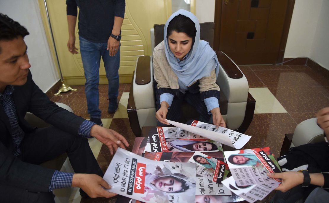 Afghan parliamentary election candidate Maryam Samaa, 26, checks her election campaign posters in Kabul on September 26.