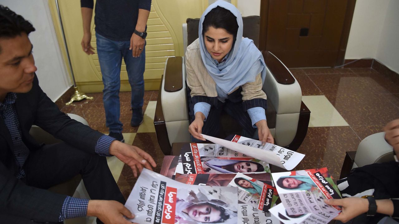 Afghan parliamentary election candidate Maryam Samaa, 26, checks her election campaign posters in Kabul on September 26.