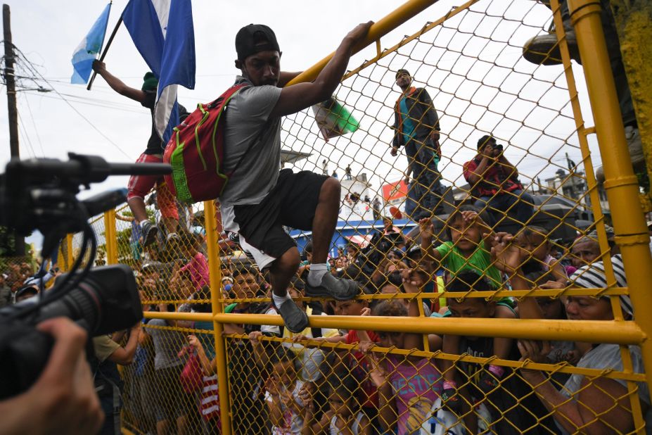 Honduran migrants heading in a caravan to the United States crowd the gate of the Guatemala-Mexico border bridge in Ciudad Hidalgo, Mexico, on Friday, October 19.
