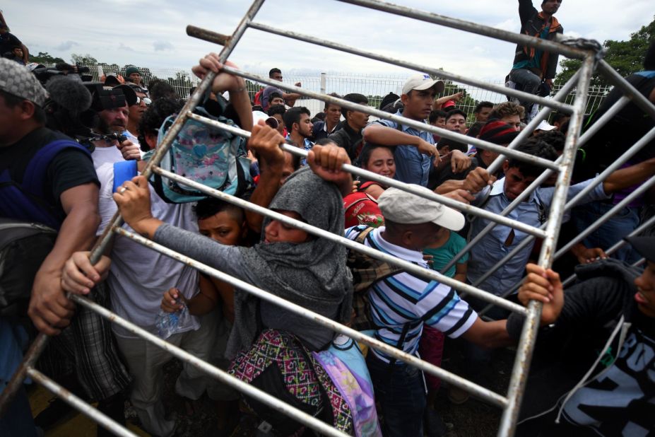 Honduran migrants heading in a caravan to the United States remove a barrier at the Guatemala-Mexico border bridge in Ciudad Hidalgo, Mexico, on Friday, October 19.