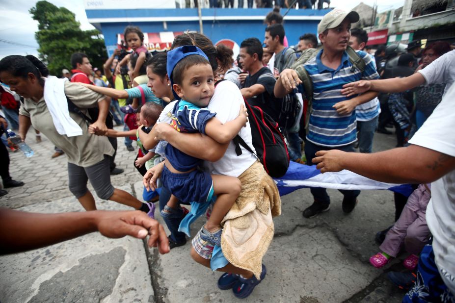 A Honduran migrant, part of a caravan trying to reach the United States, storms the checkpoint between Guatemala and Mexico in Tecun Uman, Guatemala, Friday, October 19.