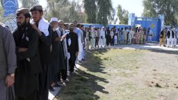 Afghan men line up to cast their votes, outside a polling station during the Parliamentary election in Helmand province, south of Afghanistan, Saturday, October 20, 2018.  Tens of thousands of Afghan forces fanned out across the country to provide security, as voting began Saturday in the elections that followed a campaign marred by relentless violence.