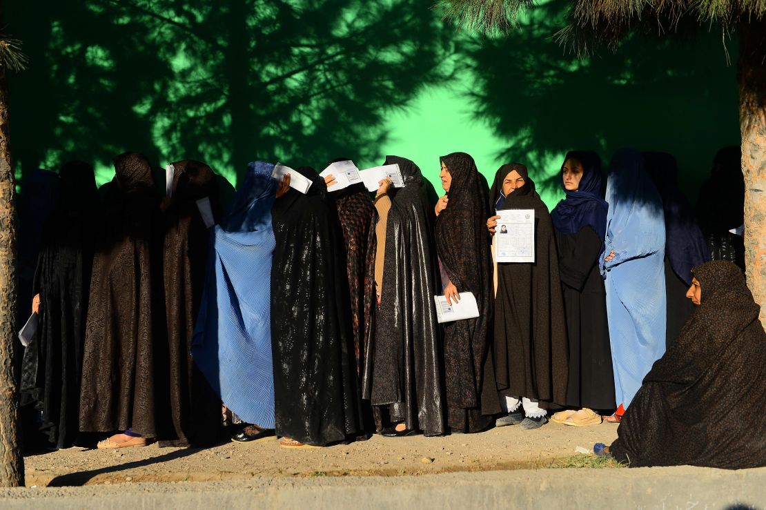 Afghan women wait in line to vote Saturday at a polling center in Herat province.