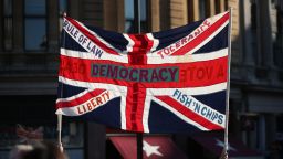 A British Union flag is held aloft bearing slogans including "Democracy", "Rule of Law", "Liberty", "Tolerance" and "Fish 'n' Chips", during the People's Vote March, in London, Saturday October 20.