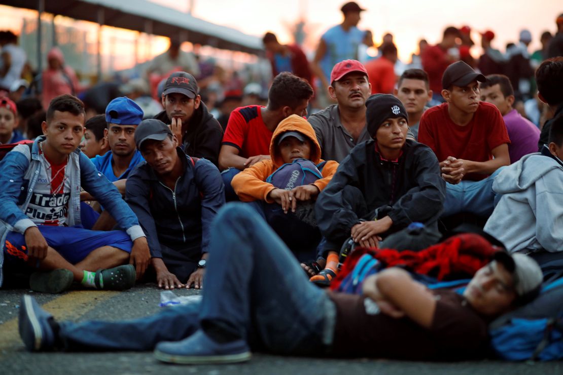 Honduran migrants wait for a gate on a bridge connecting Mexico and Guatemala in Ciudad Hidalgo, Mexico, to open.
