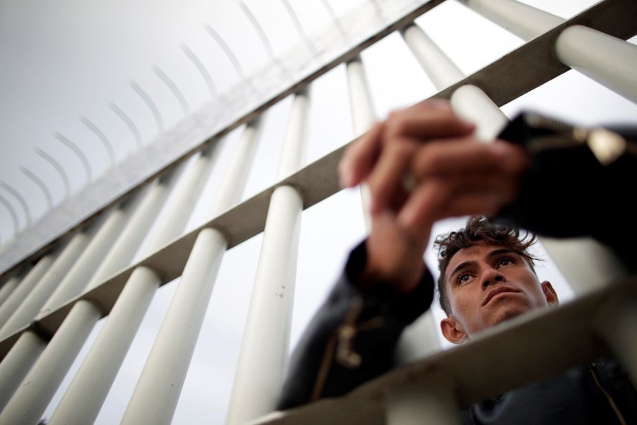 A Honduran migrant looks through the gate on the bridge that connects Mexico and Guatemala in Tecun Uman, Guatemala, on Saturday.