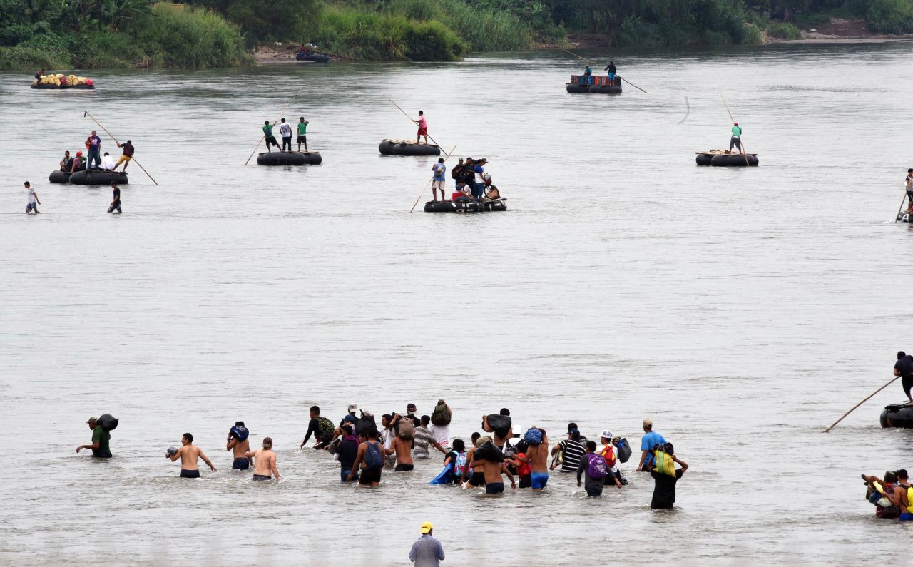 Honduran migrants from the caravan on Saturday cross the Suchiate River, a natural border between Guatemala and Mexico.